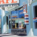 Realistic painting of a diner storefront showing a reflection in window.