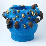 Large blue ceramic urn with black and gold protrusions.